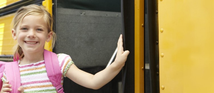 little girl and school bus going back to school