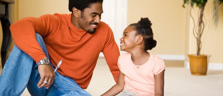 Dad and girl smiling and talking about financial literacy