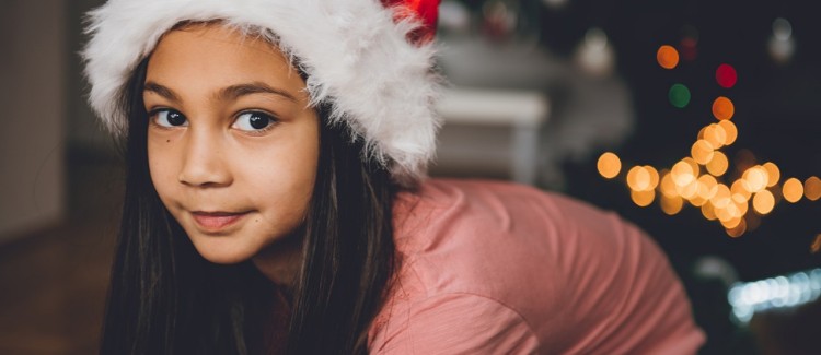 Festive girl wearing Santa hat enjoys gifts for girls