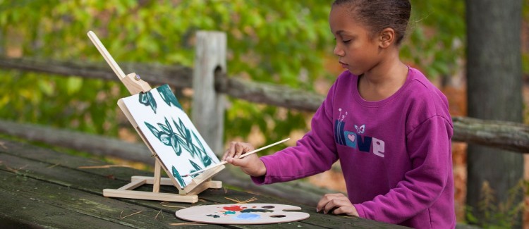 Young girl painting outside