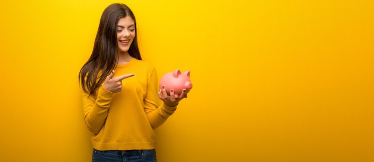 teen girl just got her first summer job and is saving money in a piggybank