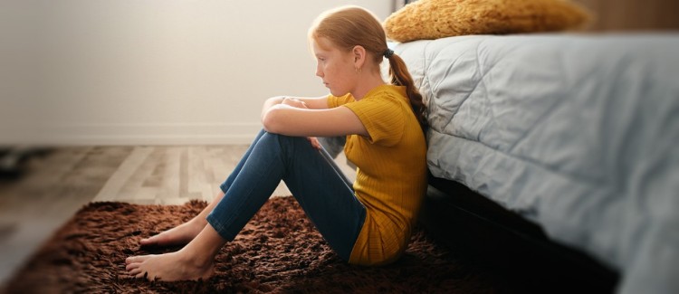 girl sitting on floor in her bedroom upset because coronavirus cancelled everything