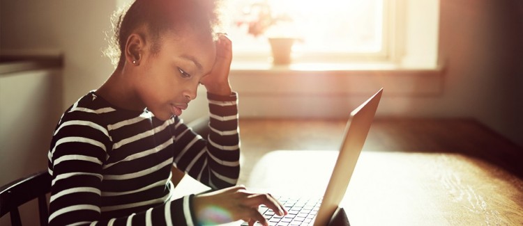 young girl struggling typing on a laptop computer