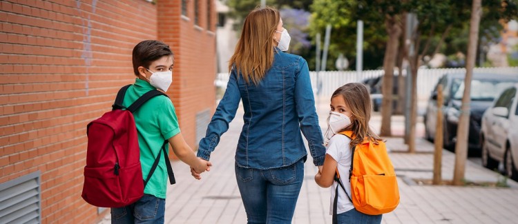 Mother takes kids to school which has opened during the COVID-19 pandemic 