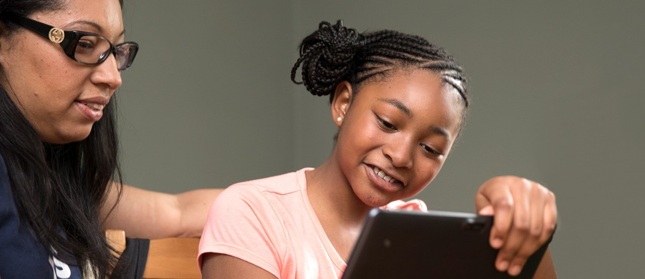 A young girl and mother doing a distance learning activity