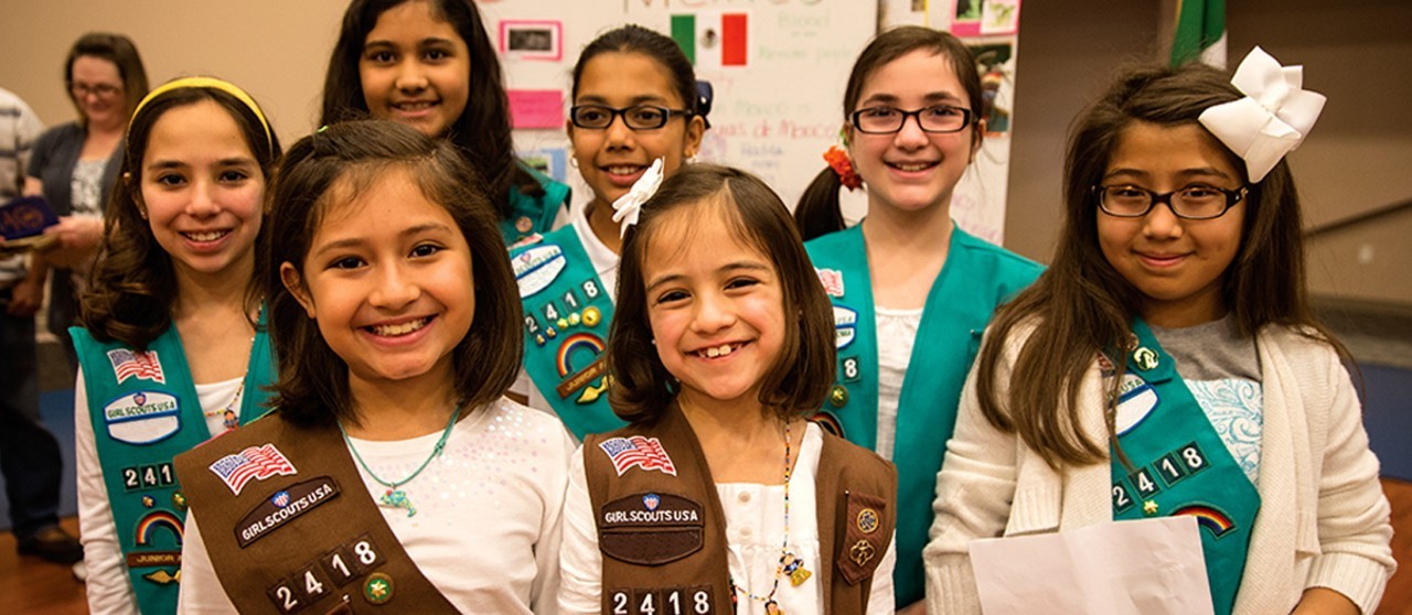 A group of Girl Scouts proudly wear their iconic uniforms